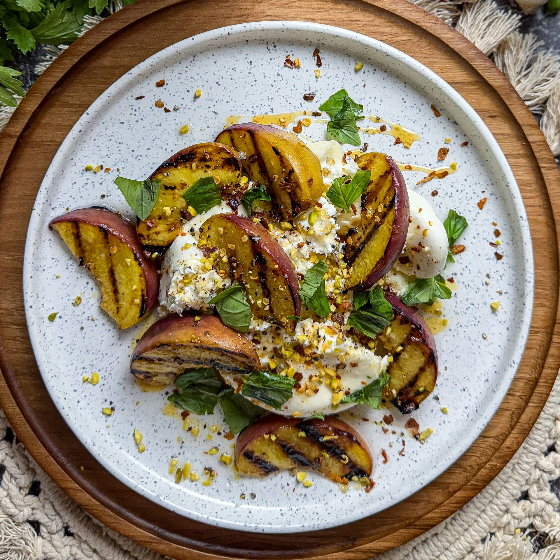 Pesche grigliate con burrata, miele piccante e pistacchi